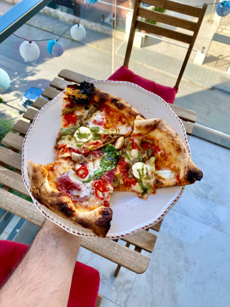 istock Take Away Pizza Slices Holding in Hand with Plate. 1319050530