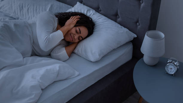 istock Stressed black lady covering ears lying in bed 1319050743