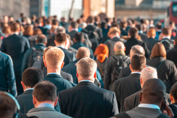 los viajeros que cruzan el abarrotado puente de londres en el camino a casa desde el trabajo, londres, inglaterra, reino unido - crowd fotografías e imágenes de stock