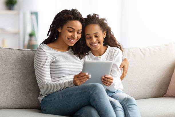 istock Happy african american mother and kid using digital tablet together 1319054495