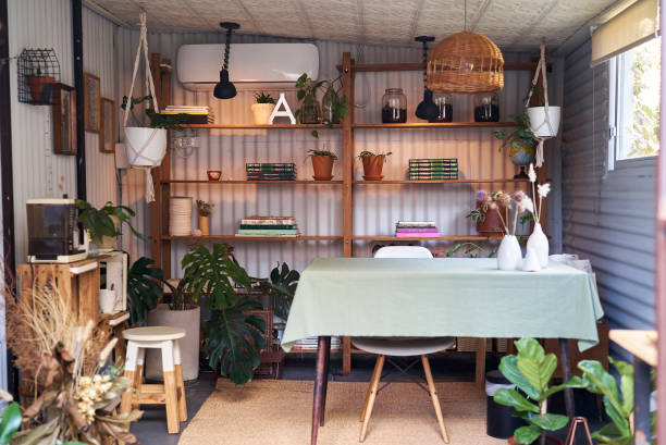 Cozy place of work with bookshelves and plants Comfortable bohemian workplace shed stock pictures, royalty-free photos & images