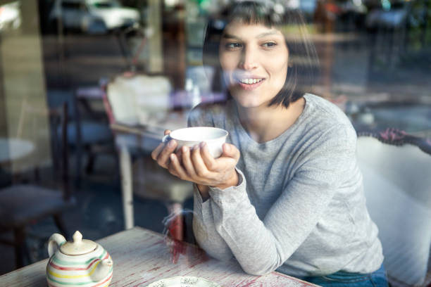 istock Satisfied store owner looking through coffee store window while having a cup of tea 1319054991