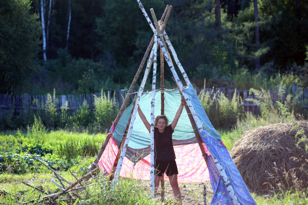 teenager-mädchen haben spaß auf dem land - teepee first nations nature camping stock-fotos und bilder