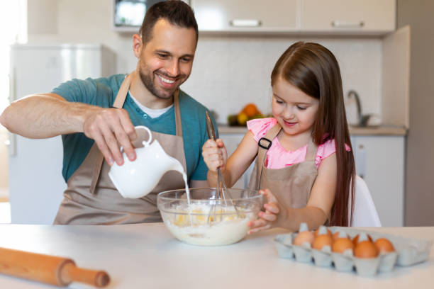 istock Happy Daughter And Father Making Dough Mixing Ingredients In Kitchen 1319056372