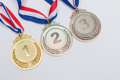 Gold, silver and bronze sports achievement medals for first, second and third place, on a white background. Olympic games and sport concept.