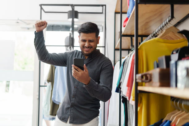 istock Happy man celebrating while looking at cellphone 1319057250