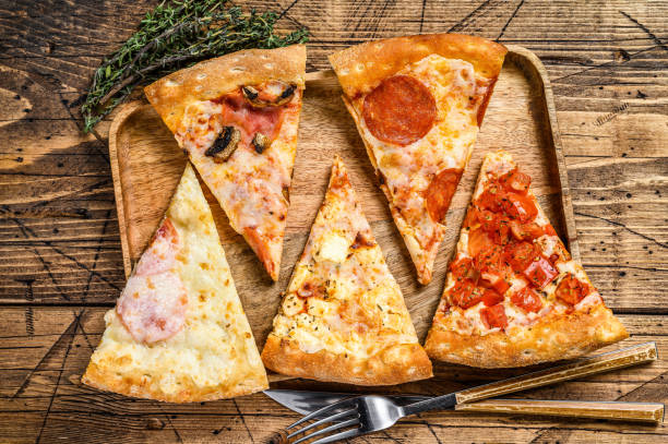 istock Pieces of different pizza various types. Wooden background. Top view 1319063220