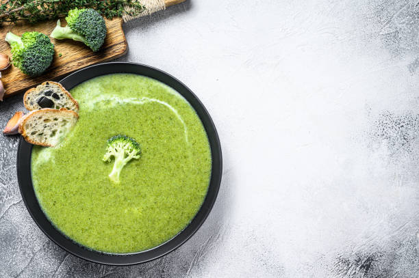 zuppa di broccoli fatta in casa con baguette fresca. sfondo bianco. vista dall'alto. spazio di copia - cream of broccoli foto e immagini stock
