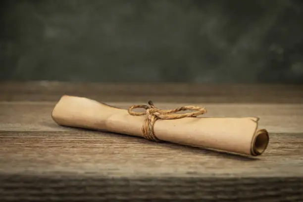 Photo of Parchment scroll with burnt edges is tied with rope