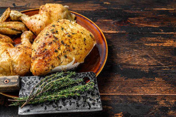 istock Butchered  baked chicken on wooden table.  Dark background. Top view. Copy space 1319064203