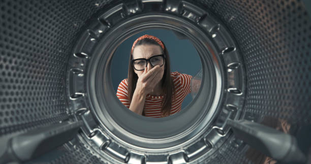 istock Woman looking into her smelly washing machine 1319064537