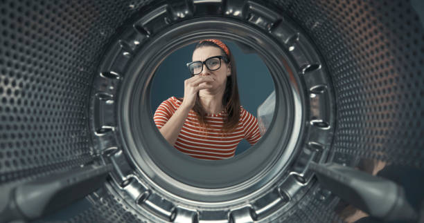 istock Woman looking into her smelly washing machine 1319064752