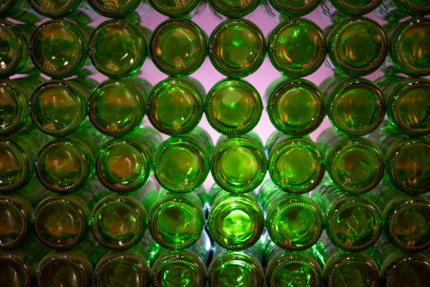 istock Green glass bottle wall background. Glass bottle wall construction. Empty wine bottles stacked-up 1319065930