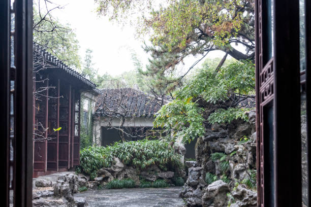 Looking through open doors of ancient houses into backyard of Suzhou garden in a rainy day In Suzhou, China. suzhou stock pictures, royalty-free photos & images