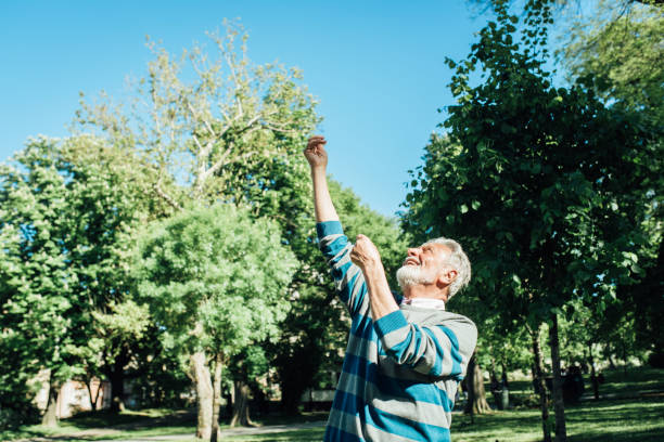 istock Happy senior man launching a kite and having fun 1319068069