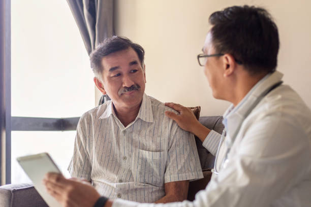 doctor reassuring supporting senior patient in hospital Smiling doctor consoling senior adult patient in medical clinic. Kind caring therapist or caregiver helping older retired man talking, giving comfort, expressing care concept. patience stock pictures, royalty-free photos & images