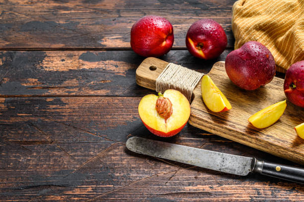 istock Cut nectarines on a wooden cutting Board. Wooden background. Top view. Copy space. 1319068699