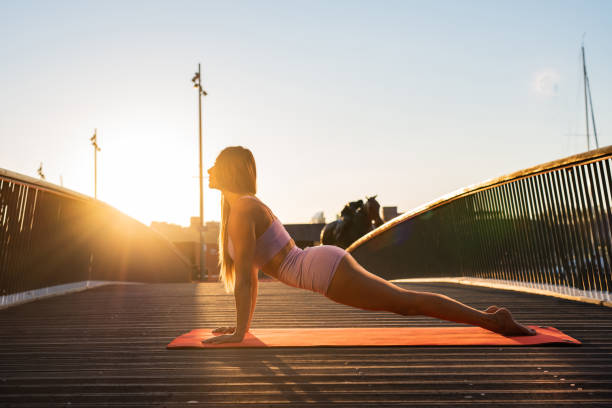 istock Female doing Yoga exercise during sunset outdoors 1319070795