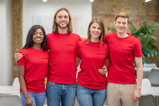 istock Group of smiling young people volunteers standing embracing 1319072185
