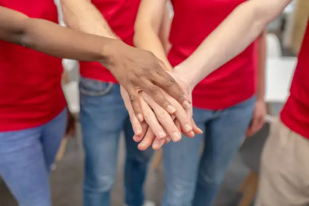 Photo of Hands of volunteers in handshake showing unity