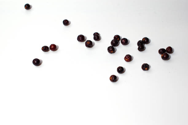 istock Dried juniper berries are scattered on a white background. Seasoning. Isolate. 1319074444