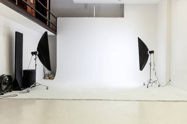 istock Empty photo studio with lighting equipment. Photographer workplace interior with professional tool set gear. Flash light white background scenes ready for studio shooting. Modern photographer studio 1319074929
