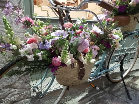 Old bicycle leaning in the street, decoration purposes,  crate with beautiful rose flower bunch. Valença de Minho, Portugal.