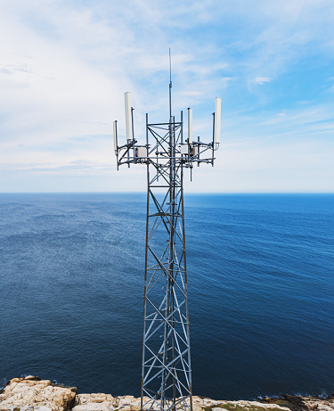 Aerial drone view of a radio/cellular tower on the Atlantic coast.