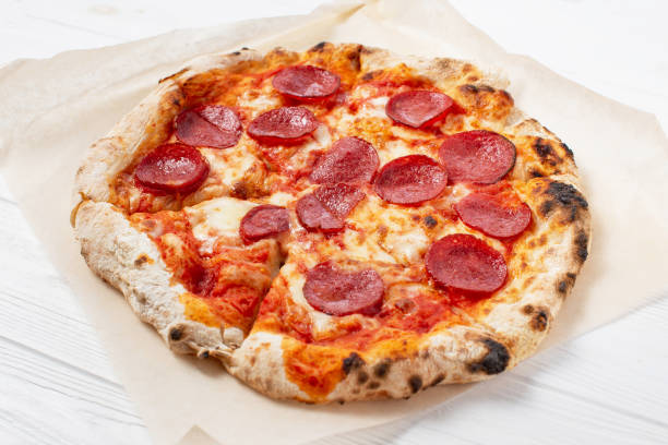 istock Pepperoni pizza on a white wooden table background 1319082581