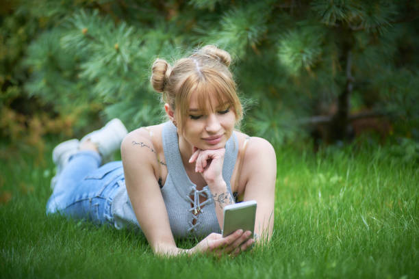 istock Woman Enjoying Using her smart phone in the Outdoors 1319084658