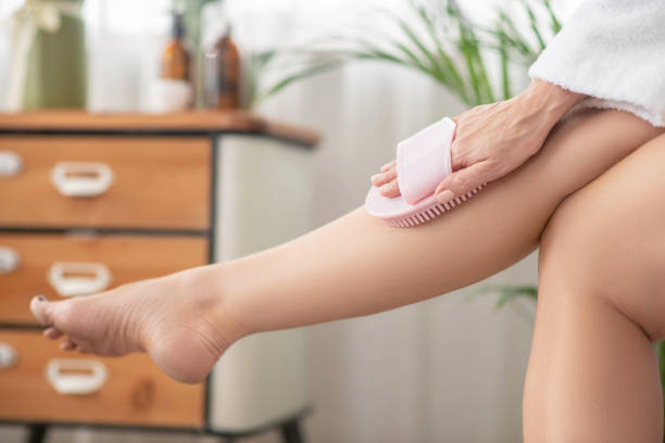 istock Woman in white massaging her legs with massaging device 1319084794