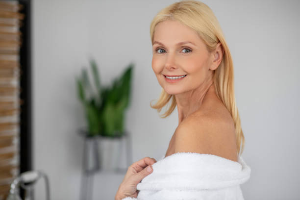 istock Pretty woman in a white robe with naked shoulders 1319084825