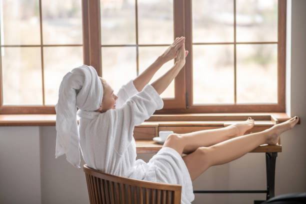 istock A woman in a white robe relaxing at home 1319084977