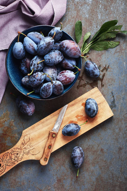 ciruelas recién recogidas en un tazón. - plum fotografías e imágenes de stock