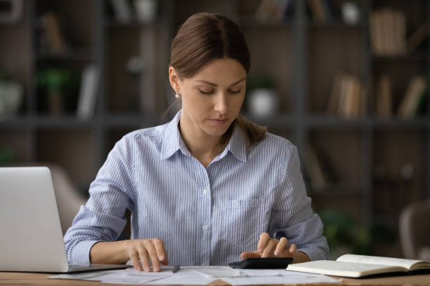 istock Millennial female social worker counting subsidy rates at office workplace 1319087312