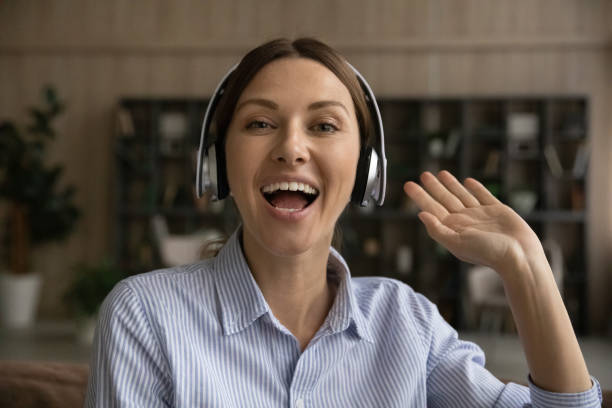 istock Active female blogger in headphones look at camera greet audience 1319087435