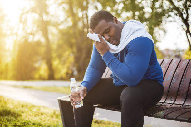 homme fatigué se reposant de l’exercice - men weight training african descent male photos et images de collection