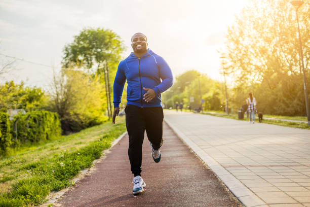 Man jogging Young man enjoys jogging. overweight man stock pictures, royalty-free photos & images