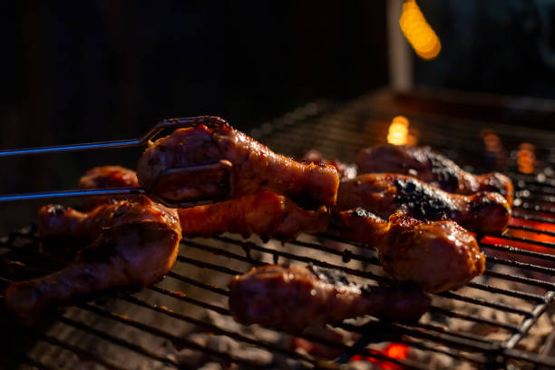 Chef cooking jerk barbecue BBQ chicken on the grill hand turning food stock photo