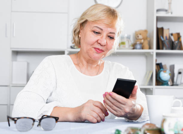 istock Mature woman with smartphone 1319091499