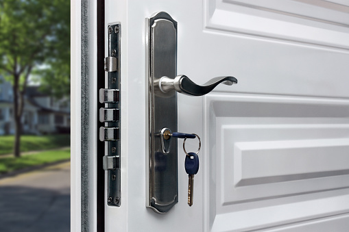 Modern glass and metallic dark front door with chrome handle and digital lock from inside, copy space