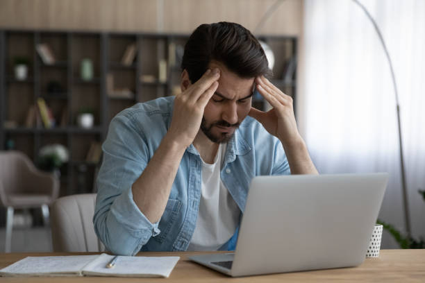 istock Upset businessman touching temples, suffering from strong headache at workplace 1319095690