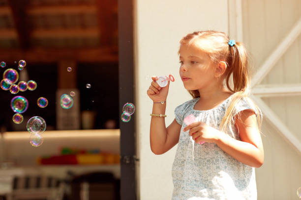 istock adorable cute little girl making soap bubbles 1319098998