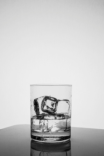 Drinking glass with condensation and ice