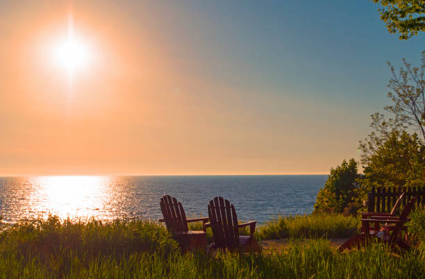 sunset on lake michigan with adirondack chairs-dennis michigan - lago michigan imagens e fotografias de stock