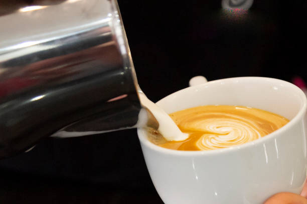 istock barista's hand drawing a picture on the coffee cup 1319100492