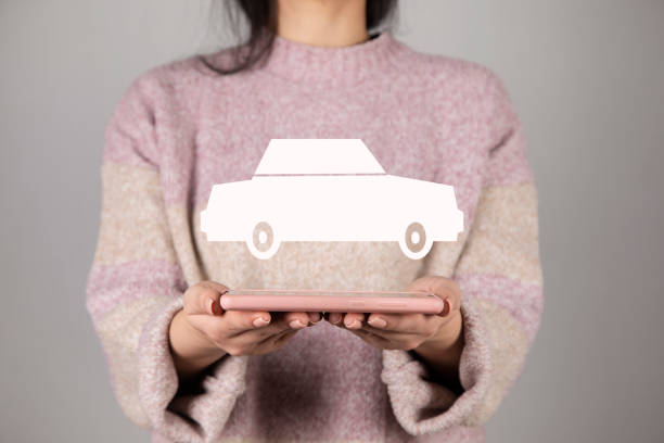 istock woman holding phone with car icon 1319100812