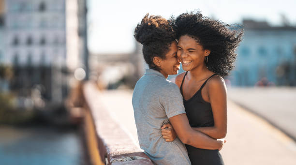 pareja lesbiana sonriendo al aire libre - frizzy 20s adult african descent fotografías e imágenes de stock