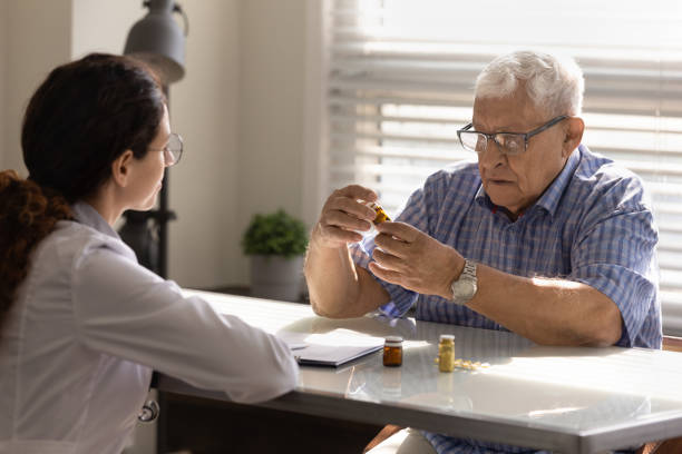 istock Focused aged man examining bottle with pharmaceuticals at therapist office 1319103317