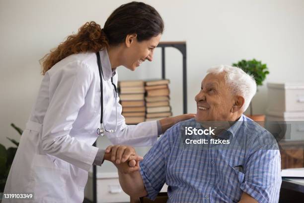 Thankful Mature Sick Man Holding Nurse Hand Appreciating For Help Stock Photo - Download Image Now